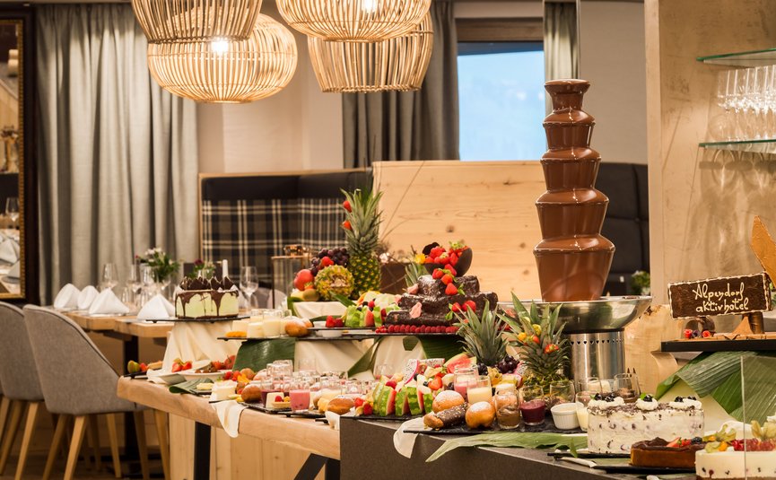 Buffet mit Schokoladenbrunnen, Kuchen und Obst in elegantem Restaurant