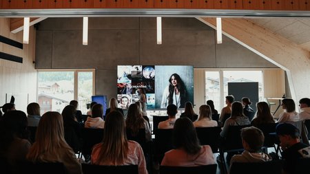Menschen sehen eine Präsentation auf einem Bildschirm in einem modernen Raum