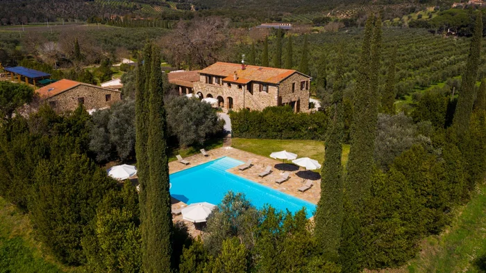 Gravelbiken in der Toskana © Tenuta il Cicalino Steinhaus mit Pool umgeben von Bäumen in einer grünen Hügellandschaft