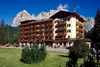 Hotel Villa Argentina with mountains and green lawn under clear blue sky