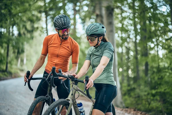 Slowenien © Tobias Köhler Mann und Frau mit Helm und Radfahrkleidung auf Waldweg mit Rennrädern