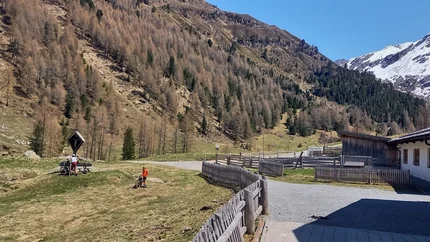 Berglandschaft mit Fahrradfahrern und einem Haus im Tal