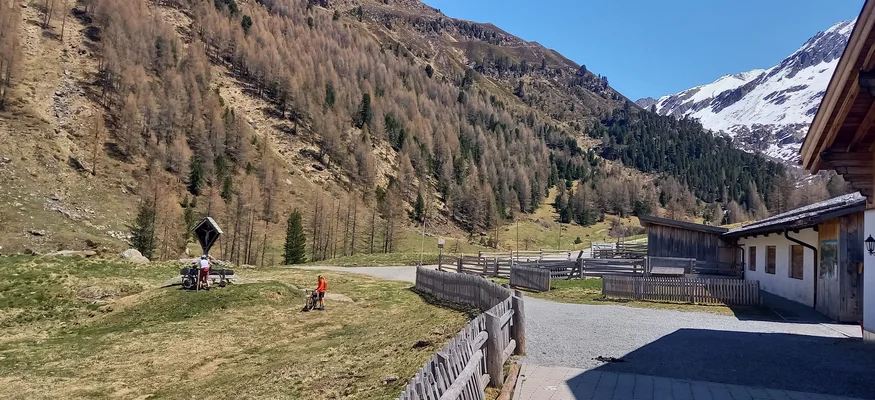 Berglandschaft mit Fahrradfahrern und einem Haus im Tal