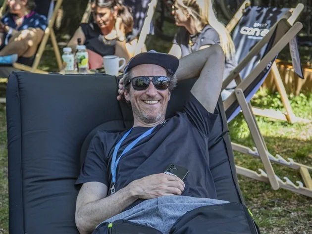 Das war das Ride ’n Gravel Testival 2026! © Sport Conrad-Leon Hoesch Mann entspannt auf Liege im Freien, im Hintergrund sitzen Frauen auf Stühlen