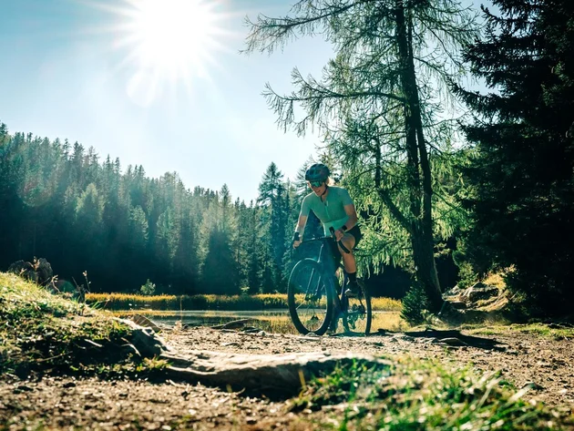 Das waren die Golden Days in Nauders © TVB-Tiroler-Oberland-Nauders-Christian-Penning - Gravelbiken in Nauders Radfahrerin mit Helm auf einem Waldweg bei Sonnenschein