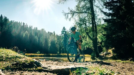 Das waren die Golden Days in Nauders © TVB-Tiroler-Oberland-Nauders-Christian-Penning - Gravelbiken in Nauders Radfahrerin mit Helm auf einem Waldweg bei Sonnenschein
