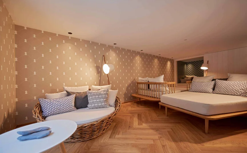 Modern eingerichtetes Wohnzimmer mit Sofa, Bett und warmem Holzfußboden