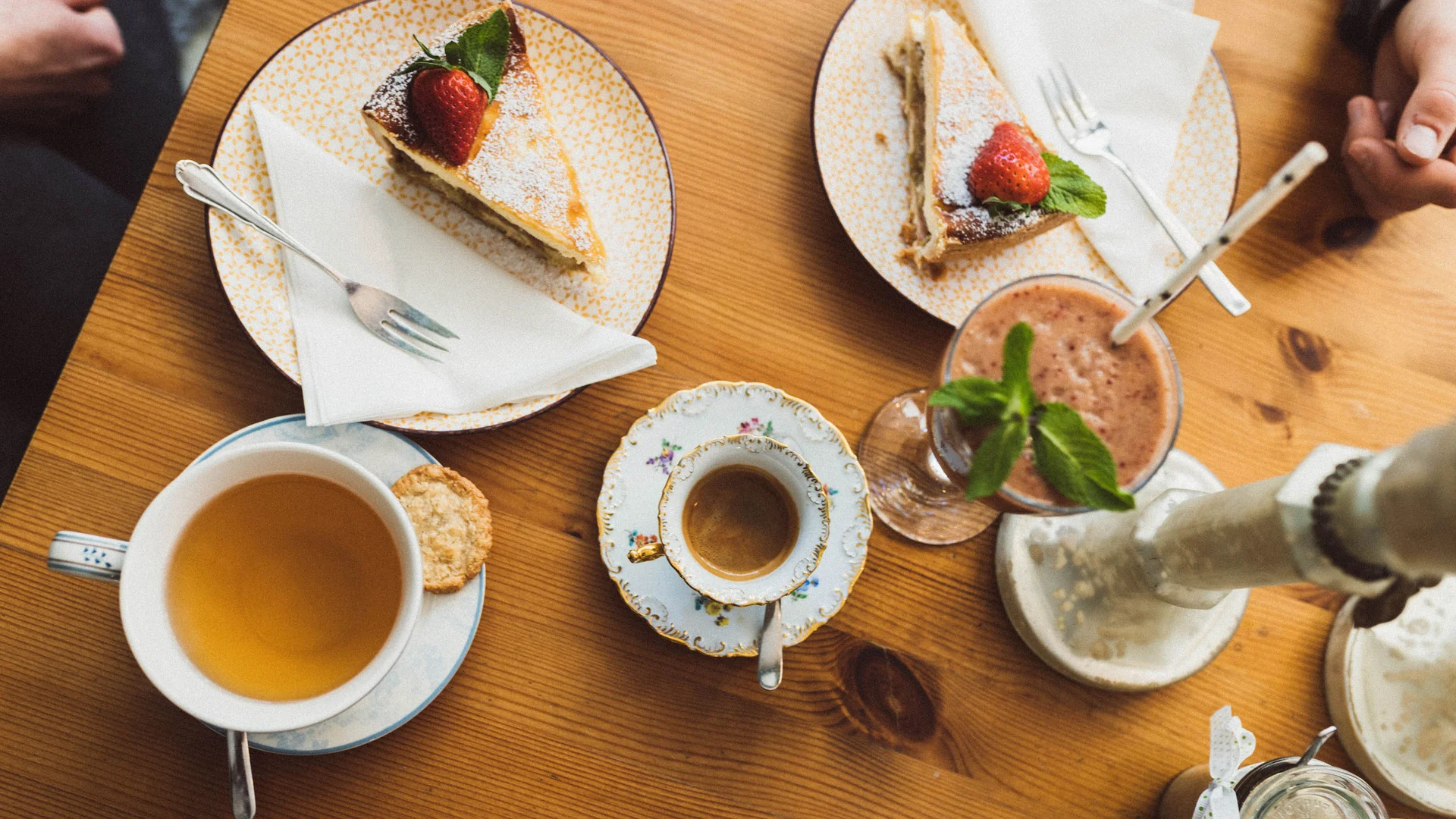 5 Tipps fürs Graveln in Oberbayern © Elisabeth Kellerer Tee, Espresso, Smoothie und Erdbeerkuchen auf Holztisch serviert