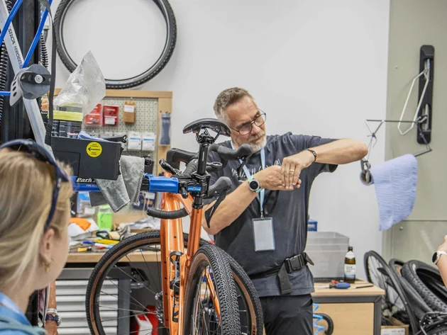 Das war das Ride ’n Gravel Testival 2026! © Sport Conrad-Leon Hoesch Mann repariert Fahrrad in Werkstatt, orange Fahrrad im Vordergrund