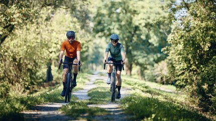 Menina Planina © Tobias Köhler Zwei Radfahrer fahren auf einem grasbewachsenen Waldweg