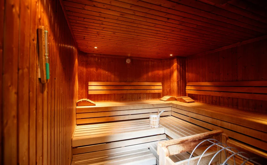 Interior of a bright wooden sauna with bucket and ladle