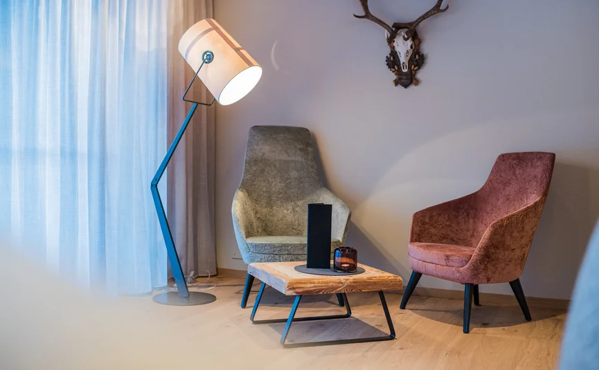 Cozy seating area with two chairs, wooden table, and floor lamp