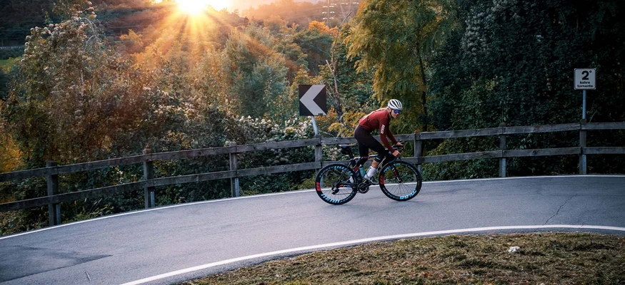Checklist für das Bikepacking-Abenteuer © Maria Wilke Radfahrer fährt auf bergiger Straße bei Sonnenuntergang