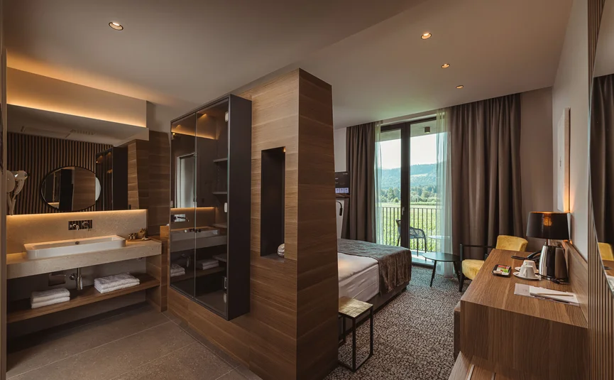 Modernes Hotelzimmer mit Holzdekor, Badbereich und Balkon mit Aussicht