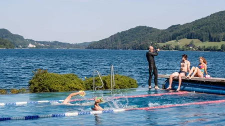 Drei Seen, eine Gravelrunde: Die 3-Seen-Tour ab Fuschl © Erwin Haiden Menschen schwimmen in einem Außenpool mit Berg- und Seeblick