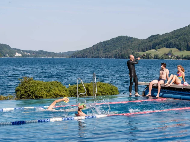 Drei Seen, eine Gravelrunde: Die 3-Seen-Tour ab Fuschl © Erwin Haiden Menschen schwimmen in einem Außenpool mit Berg- und Seeblick