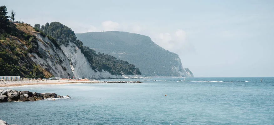 Coastline with rocks, beach, and blue sea under a clear sky