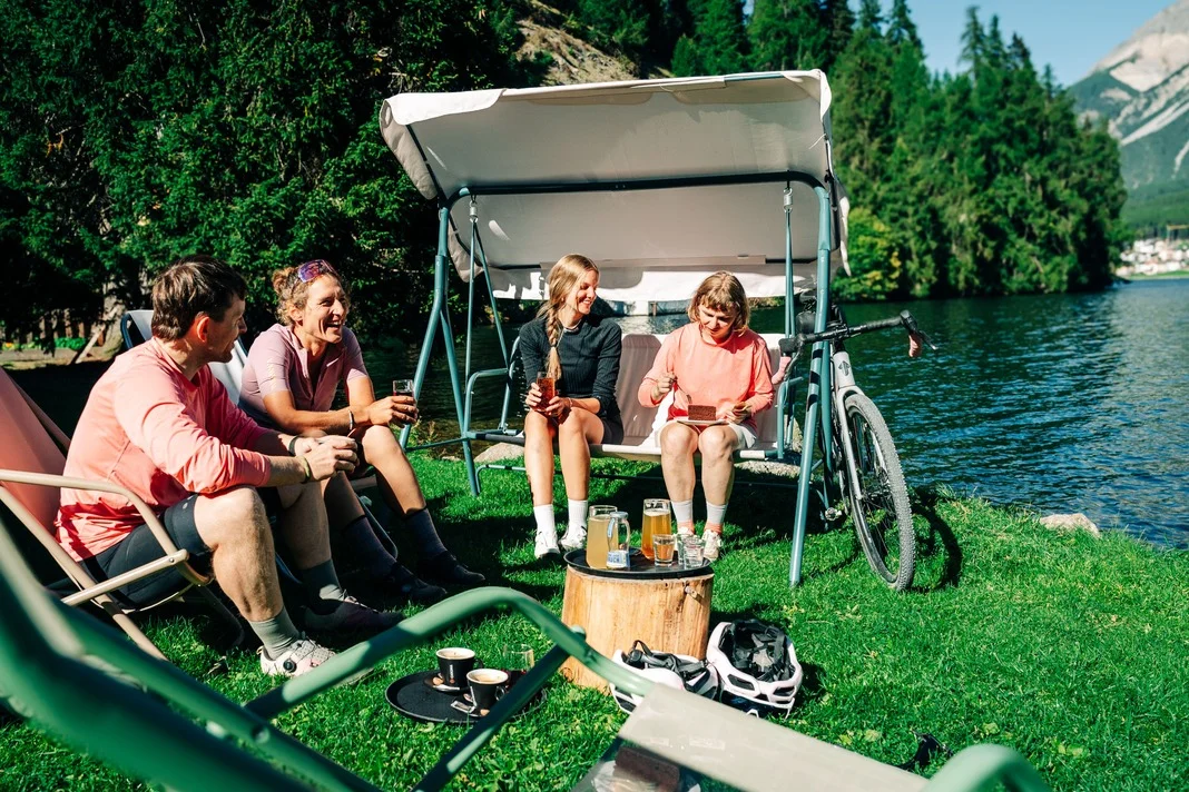 Das waren die Golden Days in Nauders © TVB-Tiroler-Oberland-Nauders-Christian-Penning Vier Freunde entspannen mit Getränken am See neben einem Fahrrad