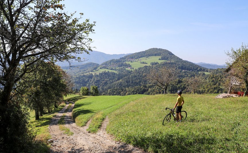 Hotel Grof **** © Kaja Ribezl Radfahrer steht auf Wiese und blickt auf bergige Landschaft