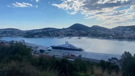 Bikepacking von Wien nach Athen © Jan Koller Hafen mit einem großen Yacht und Hügeln im Hintergrund bei bewölktem Himmel