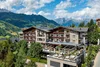 Alpendorf hotel with terrace in mountainous landscape on a sunny day