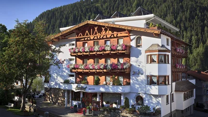 Schönes Hotel in den Bergen mit blumengeschmückten Balkonen