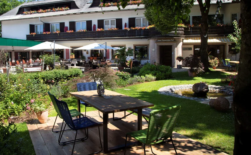 Garden terrace with table, chairs, and fountain in front of a hotel