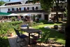 Garden terrace with table, chairs, and fountain in front of a hotel