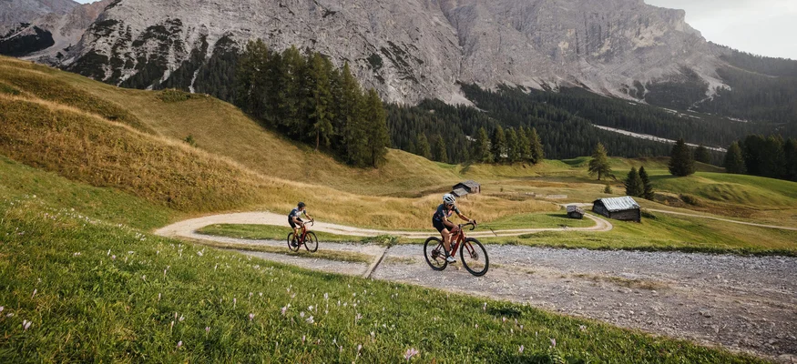 Gravel bike holidays in South Tyrol © Alex Moling Two cyclists on a mountain trail with Alps in the background