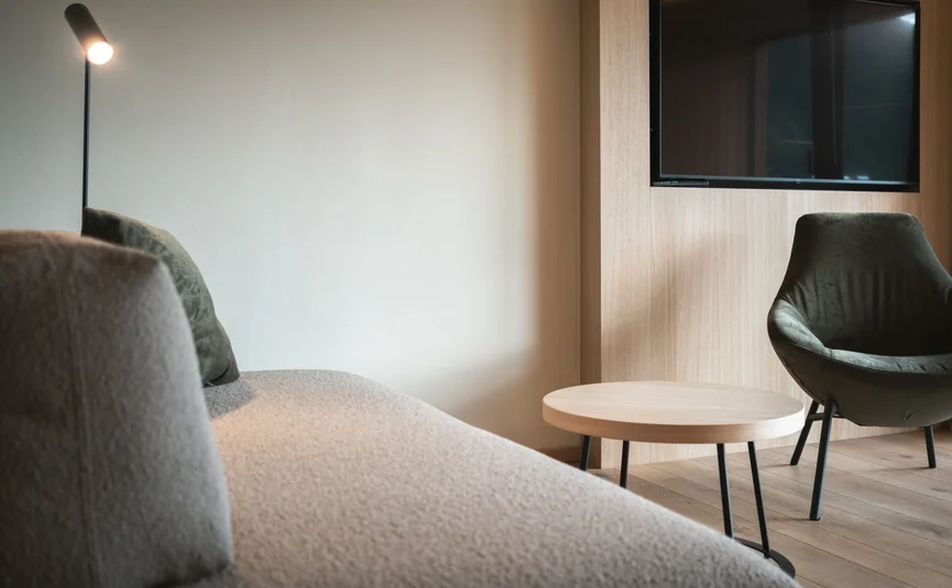 Modern living area with sofa, chair, small table, and TV