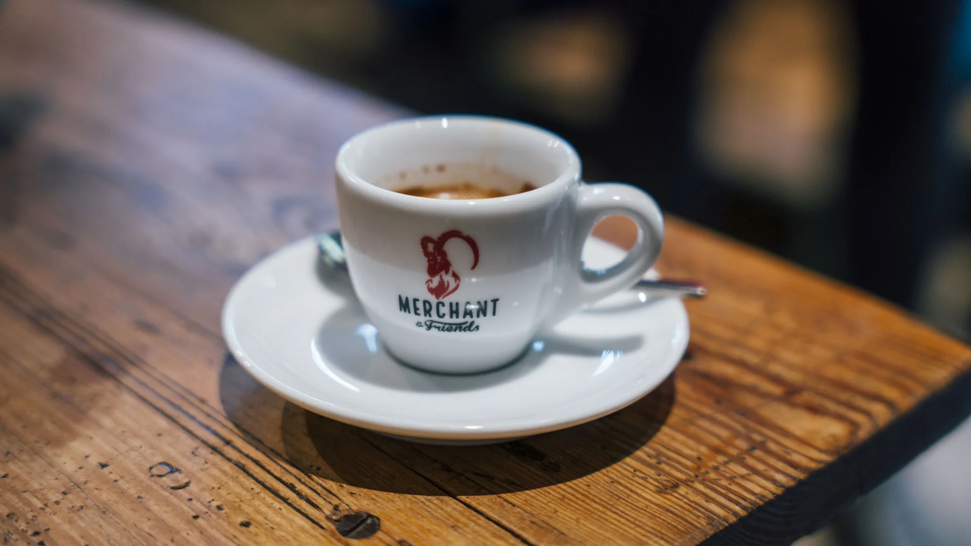 5 Tipps fürs Graveln in Oberbayern © Julian Rohn Espressotasse mit Logo auf Holztisch in Café