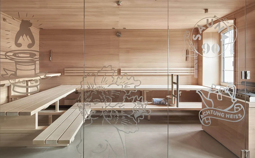 Moderner Saunaraum mit Holzbänken und dekorativem Glas