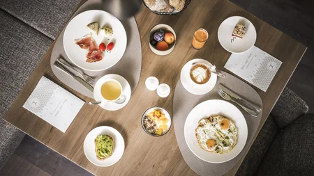 Herbst auf Schotter im Excelsior Dolomites Life Resort****s © Hannes Niederkofler Übersichtliches Frühstück mit Eiern, Avocadobrot, Kaffee, Saft und Obst