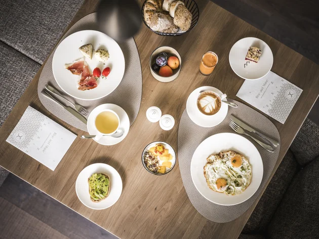 Herbst auf Schotter im Excelsior Dolomites Life Resort****s © Hannes Niederkofler Übersichtliches Frühstück mit Eiern, Avocadobrot, Kaffee, Saft und Obst