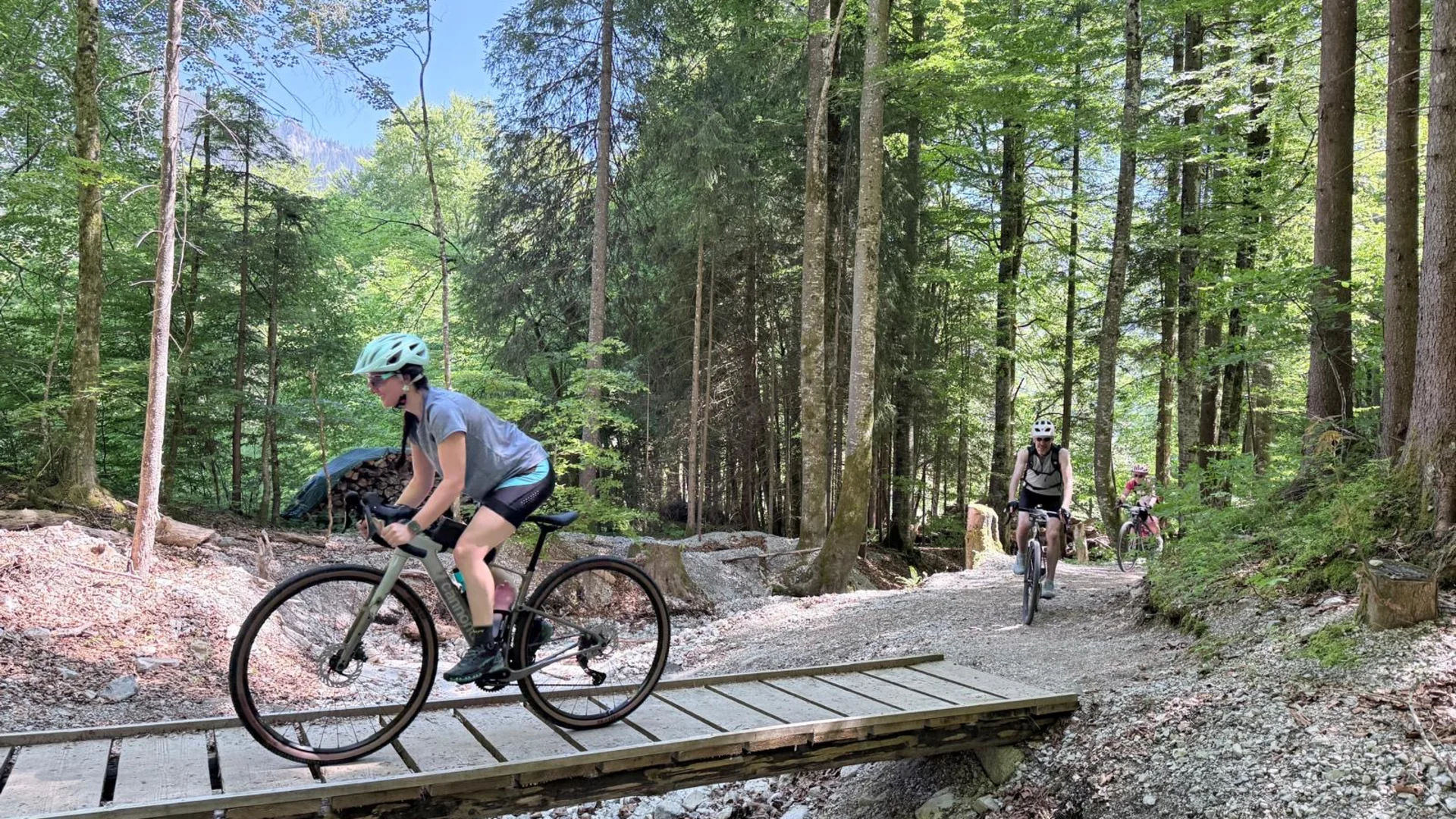 Das war das Ride ’n Gravel Testival 2026! © Sport Conrad Fahrradfahrer auf einem Waldweg über eine kleine Holzbrücke bei Sonnenschein