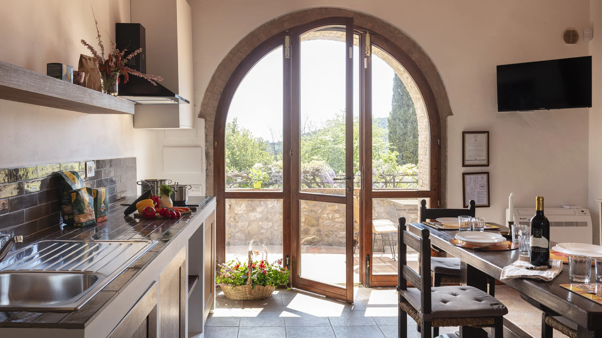 Gravelbiken in der Toskana © Tenuta il Cicalino Helle Küche mit offenem Bogenfenster, Esstisch und Blick auf Terrasse und Garten