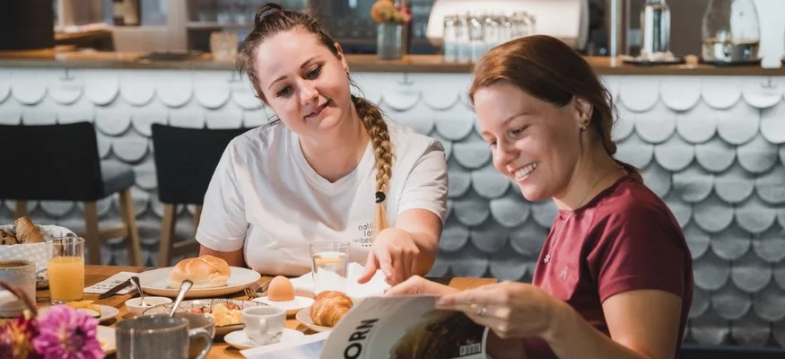 Gravelbikeurlaub im Hotel Rössle
© Nussbaumer Photography Zwei Frauen beim Frühstück und Lesen in einem Magazin im Café