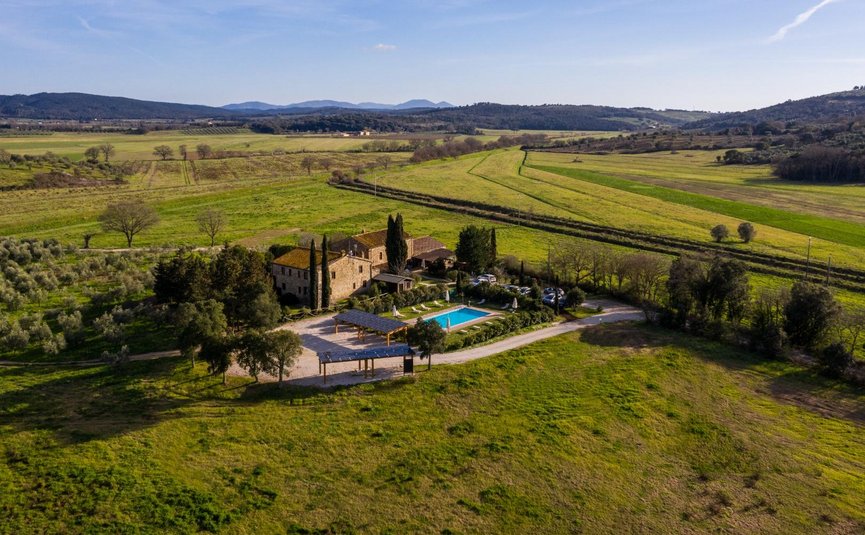 Ländliches Anwesen mit Pool umgeben von grünen Feldern und Hügeln