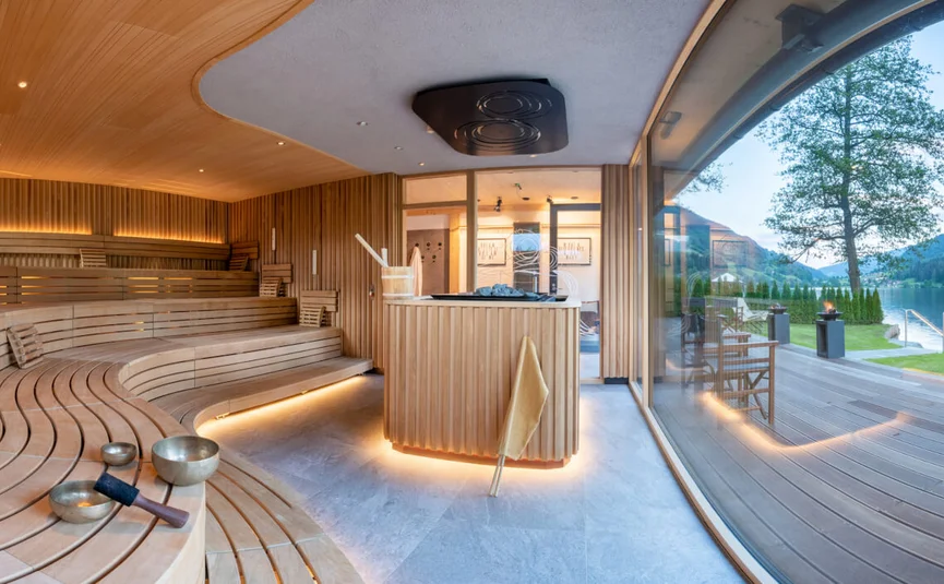 Moderne finnische Sauna mit Holzinterieur und Blick auf See und Berge
