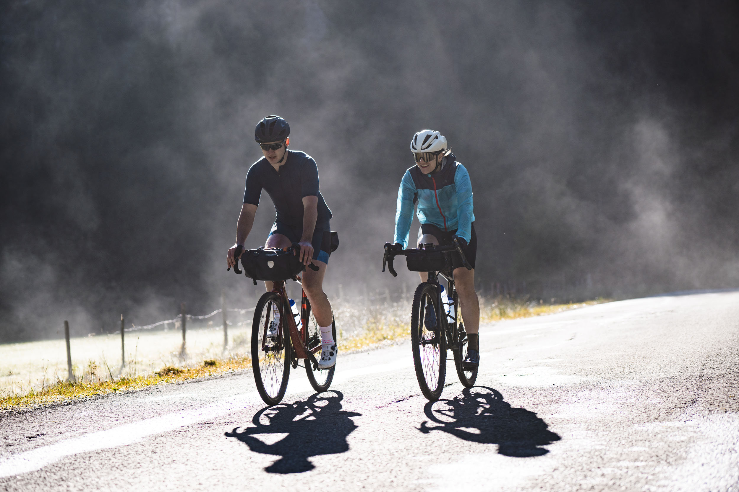 Zwei Radfahrer fahren auf einer Straße bei nebligem Wetter
